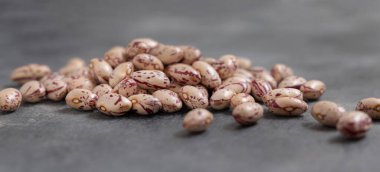 Gri masa üzerinde kurumuş fasulye yığını. Sağlıklı vejetaryen yemekleri, protein kaynakları. Geleneksel Latin Amerikalı kuzen malzemesi