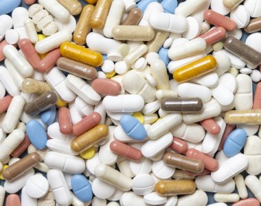 Karışık beyaz, sarı ve mavi tıbbi kapsüller ve haplar. Tıbbi tedavi için. Beslenme takviyeleri ve vitaminler alıyor. Çeşitli ilaç ürünleri.