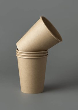 Koyu gri arka planda tek kullanımlık kağıt bardaklar. Reklam alanı olan bir model. Boş karton kahve fincanları. Plastik ve sürdürülebilir yaşam tarzı kavramı yok 