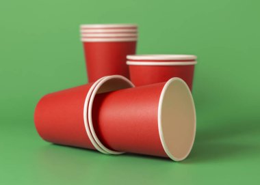Yeşil arka planda tek kullanımlık kırmızı bardaklar. Reklam alanı olan bir model. Boş karton kahve fincanları. Plastik ve sürdürülebilir Noel kavramı yok 