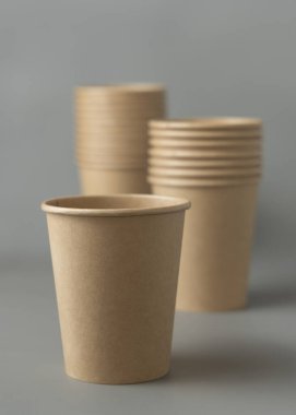 Koyu gri arka planda tek kullanımlık kağıt bardaklar. Reklam alanı olan bir model. Boş karton kahve fincanları. Plastik ve sürdürülebilir yaşam tarzı kavramı yok 