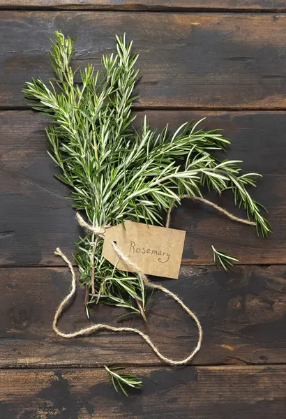 Kraft kağıt etiketli taze biberiye filizi eskimiş ahşap masa manzaralı. Aromatik olsun.