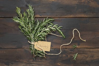 Kraft kağıt etiketli taze biberiye filizi eskimiş ahşap masa manzaralı. Aromatik olsun.