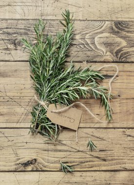 Kraft kağıt etiketli taze biberiye filizi eskimiş ahşap masa manzaralı. Aromatik olsun.