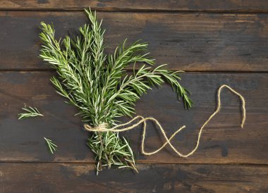 Koyu eskimiş ahşap masa manzaralı taze biberiye filizleri. Et ve balık için otlar. Akdeniz mutfağı konsepti