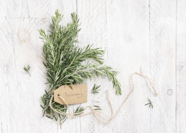 Beyaz yıpranmış ahşap masa manzaralı Kraft kağıt metin etiketli taze biberiye filizleri. Aromatik olsun.