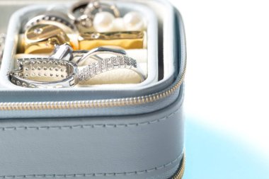 Açık mavi, kadınlar, küpeler ve yüzükler için aksesuarlar içeren mücevher kutusunu açtı. Yakın plan makro, beyaz arkaplan üzerinde izole