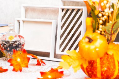 Kabaklı boş fotoğraf çerçeveleri ve dolaptaki akçaağaç yapraklarından bir çelenk, yakın plan.