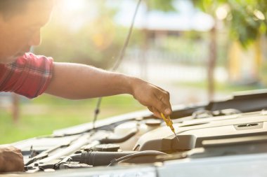 Car service and maintenance concept : Asian man checking his car or fixing engine of modern car before start the trip