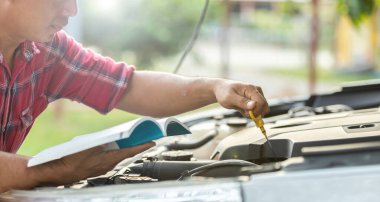 Car service and maintenance concept : Asian man checking his car or fixing engine of modern car before start the trip
