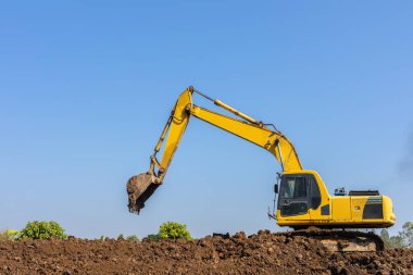 Excavator digging. Digger machine adjusting ground level in construction site.