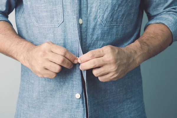 Homem Abotoar Camisa Azul Jeans Estúdio Tiro Fundo Parede Cinza — Fotografia de Stock