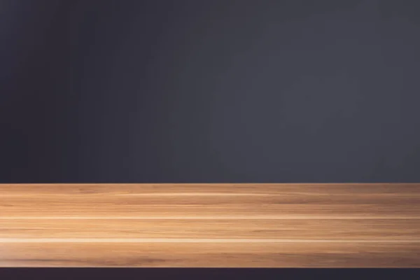 木制桌子的顶部空间是空的 深灰色墙壁背景上的褐色木制桌面 适用于广告展示或产品展示 图库照片