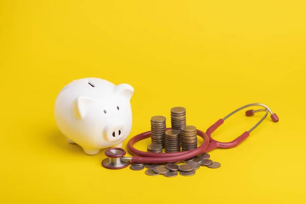 Financial for health concept The idea of saving money for healthcare, Close up stethoscope and white piggy bank on yellow color and copy space background. Health and finance concept