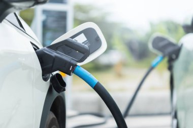 Elektrikli araba kullanma kavramları. Elektrikli araba kullanıcısı, elektrikli arabayı şarj etmek için siyah bir şarj aleti tutuyor. Elektrikli arabaların Tayland 'da en son alternatif enerji kaynağı olarak kullanılması.