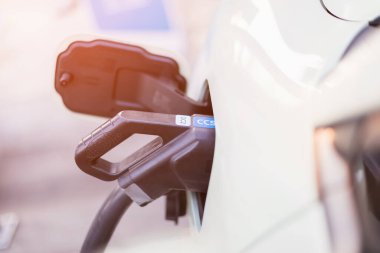 Elektrikli araba kullanma kavramları. Elektrikli araba kullanıcısı, elektrikli arabayı şarj etmek için siyah bir şarj aleti tutuyor. Elektrikli arabaların Tayland 'da en son alternatif enerji kaynağı olarak kullanılması.