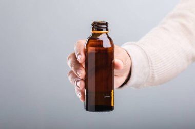 Bir adam elinde bir şişe enerji içeceği tutuyor ve bu da onun sağlığa olan etkisini sorguluyor. Enerjiyi artırıyor mu yoksa potansiyel dezavantajları mı var? Refah için bilinçli seçimler yapmanın bir yansıması.