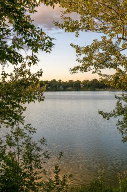 Fergus Falls, Minnesota 'daki Alice Gölü' nde sakin bir günbatımının bulutların yansımaları ve güzel renkleri.
