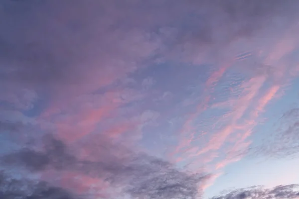 Pink and purple tinted  clouds on blue sky at sunset in Minnesota.