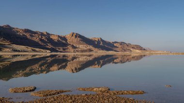 The beautiful Judean desert mountains reflected in the Dead Sea at Ein Bokek, Israel.