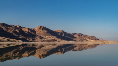 The beautiful Judean desert mountains reflected in the Dead Sea at Ein Bokek, Israel.