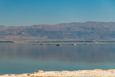 Ölü Deniz 'in parlak renkleri ve Ürdün dağlarının yansıması İsrail' de bir kış gününün şafağında.