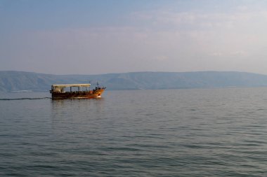 Sisli bir kış gününde Celile Denizi 'nde insanlarla dolu bir turist teknesi..