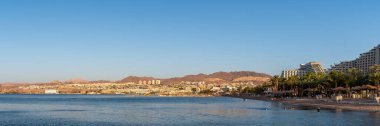 Eilat, İsrail 24 Eylül 2022 Kızıldeniz, Eilat ve denizde yüzen insanların olduğu otellerin panoramik manzarası. 
