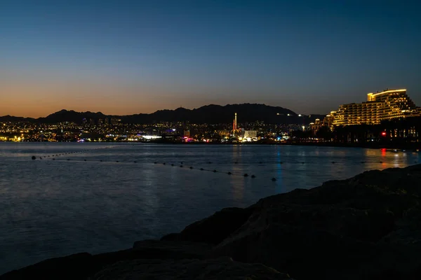 Eilat, İsrail 24 Eylül 2022 Eilat alacakaranlıkta İsrail 'de Kızıldeniz' in ışıkları altında gökyüzüne yükseldi.