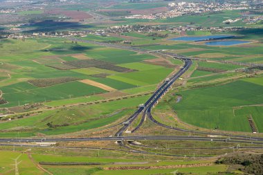 Kuzey İsrail 'de bir kış gününde yeşil tarlaları olan Jezreel Vadisi' ndeki otoyollar.