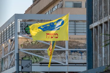 Tel Aviv, İsrail 10 Eylül 2022 Mashiach Bayrağı, Mesih Bayrağı, mor taçlı sarı bayrak ve İsrail 'in Tel Aviv kentindeki bir binada İbranice Mesih yazıyor...  