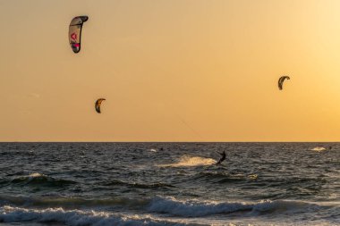 İsrail 'in Atlit kentindeki Akdeniz' de gün batımında siluet içinde uçurtma sörfçüleri.