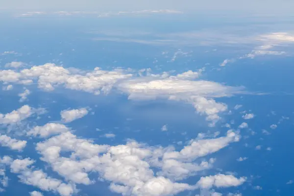 White clouds against the blue of the Pacific Ocean seen from a plane near the Hawaiian Islands