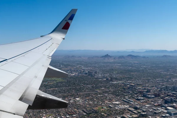 Phoenix, Arizona ve dağ manzarası kanadın bir kısmının bulunduğu bir uçak penceresinden..