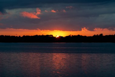 Minnesota, ABD 'deki North Turtle Gölü' nde ağaçlarla dolu renkli bir yaz günbatımı.