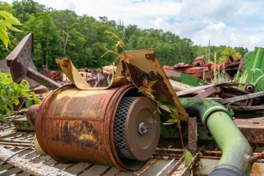 Minnesota, Birleşik Devletler 'in kırsal kesimlerindeki metal parçalarının içinde ve çevresinde otlar büyüyen makine parçaları mezarlığı..