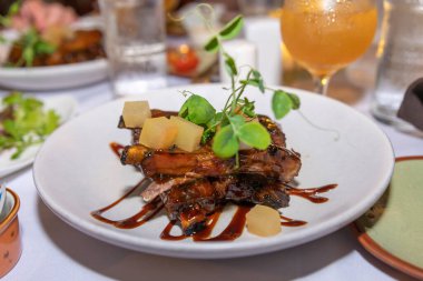 Hawaii usulü yapışkan, tatlı barbekü pirzolası, ananas parçaları ve bezelye filizi garnitürlü.. 