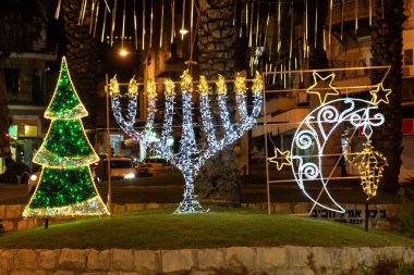 Wadi Nisnas 'taki üç büyük dini temsil eden güzel sokak dekorasyonları. Hayfa, İsrail' deki Hristiyan mahallesi. Noel ağacı, Hanukkiah, ay ve kreş..