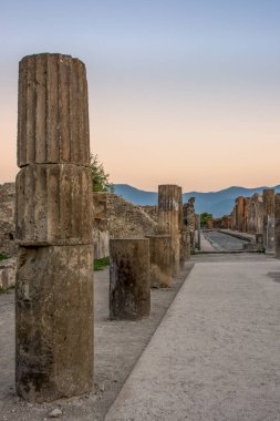 İtalya, Pompeii 'de günbatımında sütunları ve kalıntıları olan boş bir sokak..
