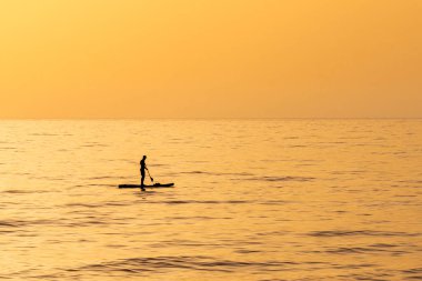 Hayfa, İsrail yakınlarındaki Akdeniz 'de siluet içinde bir adam altın saatinde güzel turuncu bir gün batımıyla birlikte.. 