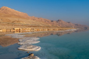 Ölü Deniz kıyısında tuz oluşumları ve İsrail 'deki Musevi Çöl Dağları.
