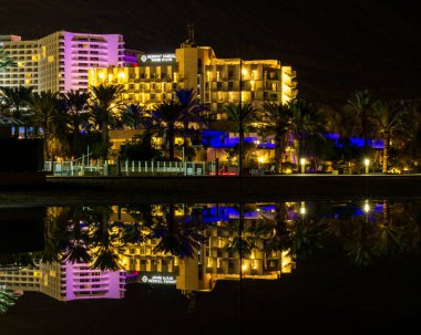 The Dead Sea, Israel December 02, 2024 Night time view of the beautiful  Herbert Samuel Hotel with reflection in the Dead Sea at Ein Bokek hotel area in israel. clipart