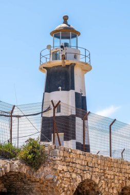 Eski siyah beyaz deniz feneri Eski Acre, Akko Israel 'in duvarlarla çevrili şehrinde.