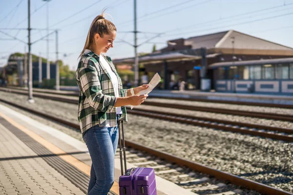 Szczęśliwa Kobieta Patrząc Mapę Stojąc Stacji Kolejowej — Zdjęcie stockowe