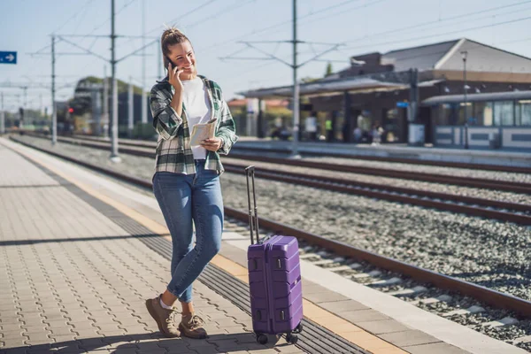 Happy Woman Using Mobile Phone Holding Map Train Station — Stock Photo, Image