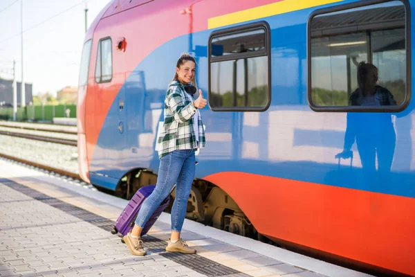 Bavullu Mutlu Kadın Tren Istasyonuna Girerken Başparmağını Gösteriyor — Stok fotoğraf