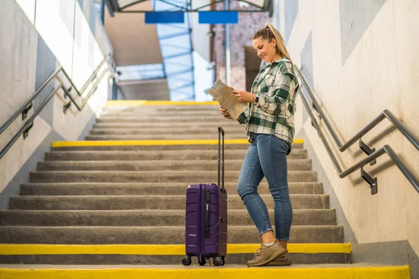 Счастливая Женщина Чемоданом Смотрит Карту Стоя Лестнице Железнодорожного Вокзала — стоковое фото
