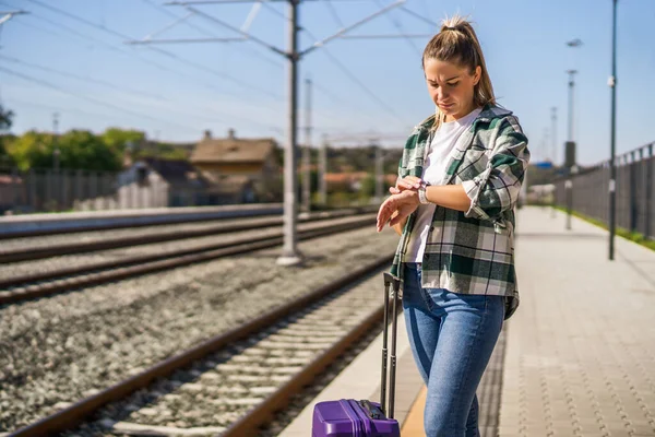 Kobieta Patrząca Zegar Stojąc Walizką Dworcu Kolejowym — Zdjęcie stockowe