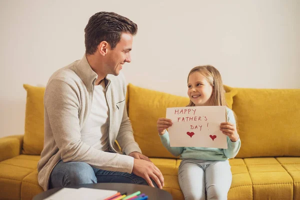 快乐的女儿为她的父亲拿着有心形和文字的贺卡 父亲节的概念 — 图库照片