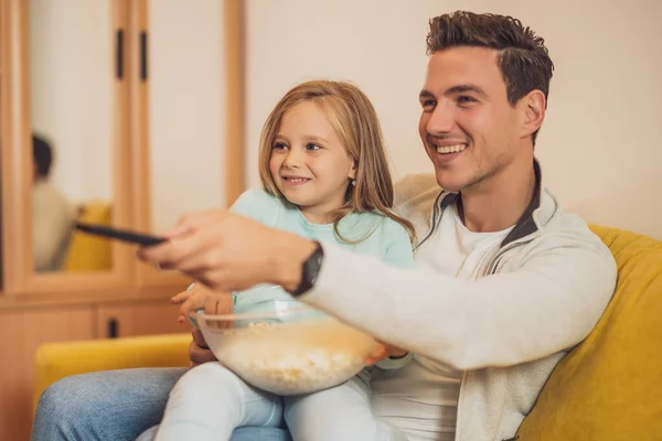 父亲和女儿都喜欢在家里看电视和吃爆米花 — 图库照片